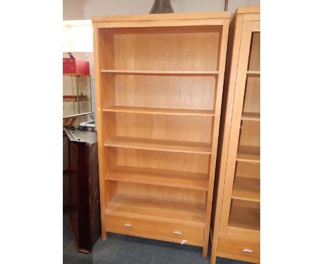 A light oak bookcase, with four shelves, above a single frieze drawer, raised on square block feet, 100.5cm x 35.5cm x 196cm.