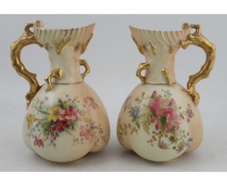A pair of Royal Worcester blush ivory coral jugs, the quarter lobe body painted with fruit, shape No. 1507, height 8.5ins