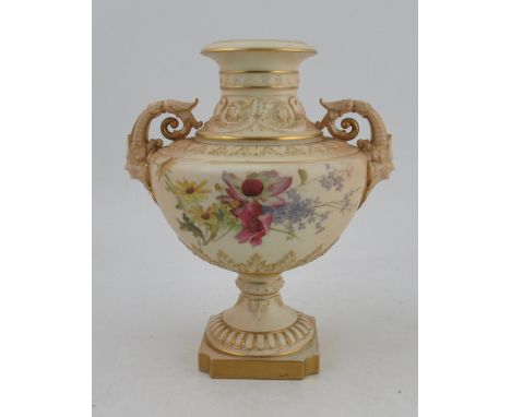 A Royal Worcester blush ivory pedestal vase, decorated with field flowers, with scrolling mask handles, shape number 1572, he