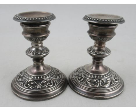 A pair of silver candlesticks, with bead and embossed decoration, height 5ins