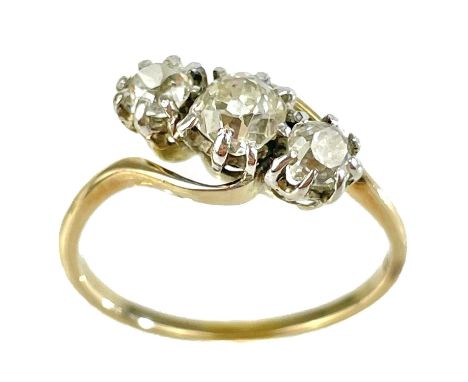 An early 20th century 18ct gold diamond set three stone crossover ring. The principle 0.50ct old European cut diamond flanked