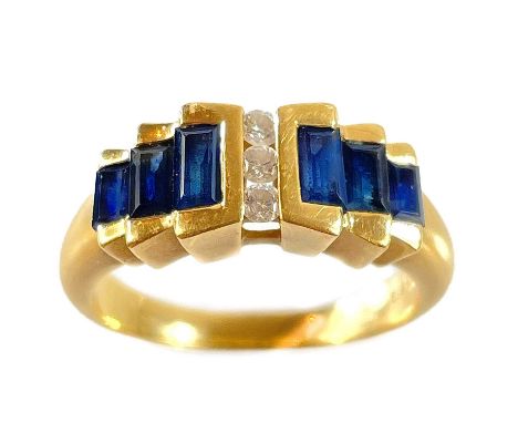 A modern 18ct gold diamond and sapphire dress ring. Set with three channel set diamonds with total weight of 0.12ct, flanked 