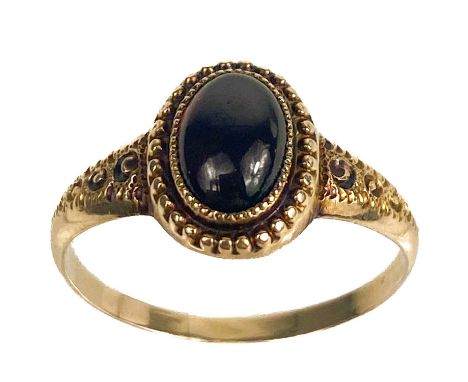 A Georgian gold foiled garnet set ring.  The oval cabonchon garnet measuring 8 x 5mm, in a beaded setting, the shank shoulder