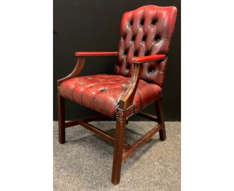 A mid 20th century button-back open arm office chair, sang de boeuf leather, mahogany arms and legs, 102cm tall 