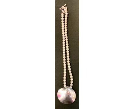 A Mexican silver and grey cultured pearl necklace, shaped silver pendant stamped TN-49, Mexico, 925, suspended from a light g