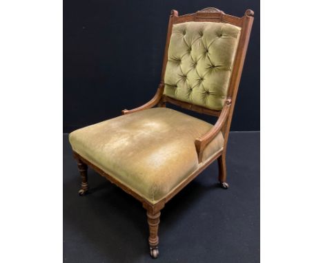 A Victorian mahogany nursing chair, carved cresting, button back, stuffed-over seat, turned legs, ceramic casters, c.1890. 