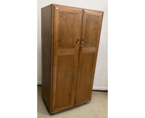 A 1960s Ercol elm two door wardrobe, Model 480-CSP38, bears "Ercol" label and retailer's label "Lee Longlands Broad Street Bi