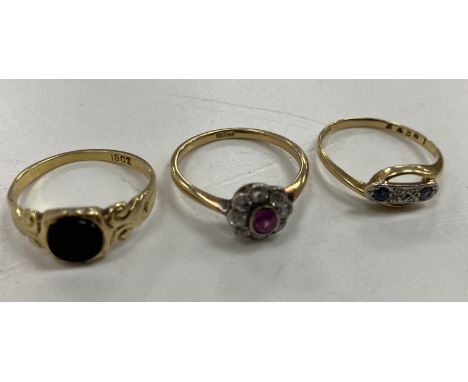 Three 18 carat gold ladies dress rings including a flower head design example with central oval cut ruby, approx 0.15 carat, 