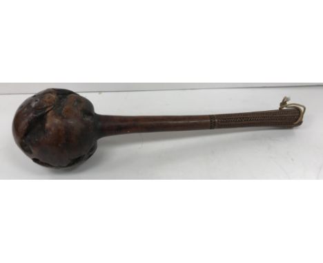 A 19th Century Zulu knobkerrie, the rough ball head on a turned handle with zigzag carved decoration to the grip 41 cm long 