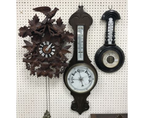 A 20th Century carved treen ware cased cuckoo clock of typical form, 30 cm wide x 47 cm high (not including chain), together 