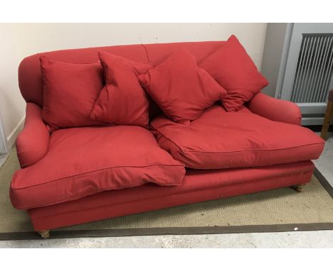A modern red felt effect upholstered sofa on turned front legs in the manner of Howard of London, 177 cm wide x 98 cm deep x 