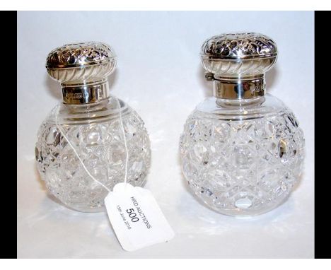 A pair of silver lidded cut glass globular scent bottles - 11cm high 