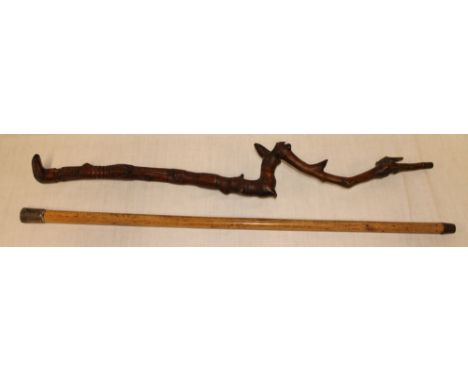 An old carved crooked walking stick and a silver mounted malucca stick (minus handle) (2) 