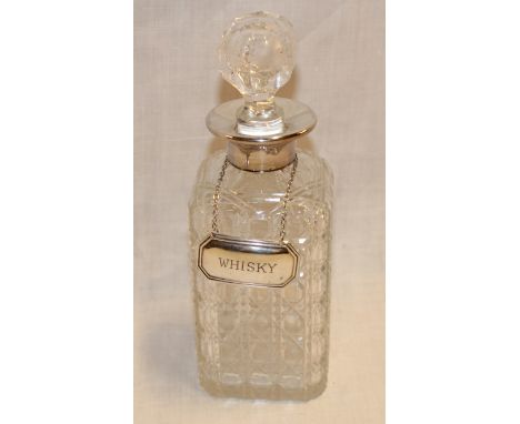 A good quality cut-glass square decanter with silver mounted rim and attached silver whiskey decanter label 