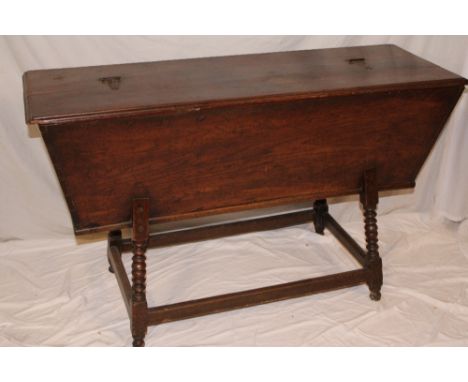 A late 18th/early 19th Century elm rural domestic food trough with sloping sides and hinged lid on turned legs 48" long 