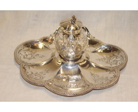 A Victorian silver scallop-shaped desk-stand with central cut-glass inkwell and matching hinged silver lid, London marks 1874