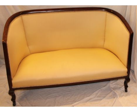 An Edwardian beech curved two seat settee upholstered in gold fabric on tapered legs, 49" long 