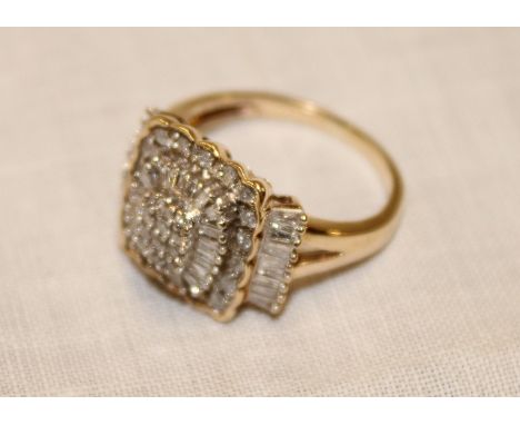 An unmarked gold dress ring with square panel mounted with baguette and natural diamonds (4.4g)