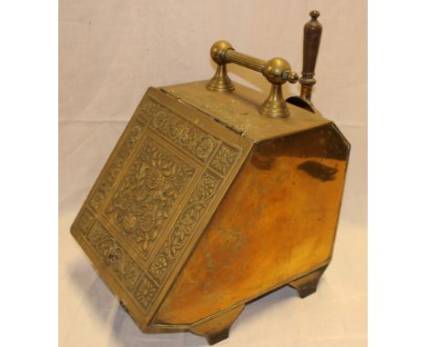 An Edwardian brass coal box with hinged sloping embossed cover and matching shovel