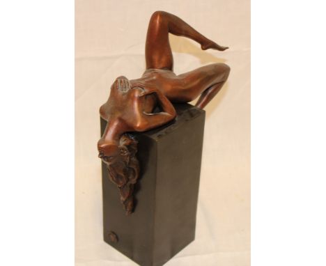 A modern French bronze figure of a nude reclining female mounted on a composition square plinth, 11" high