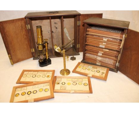 An old brass monocular microscope with various attachments in fitted case together with a case containing a selection of micr