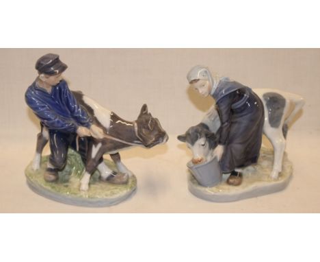 A pair of Royal Copenhagen china figures of a boy and girl feeding calves, 6½" long 
