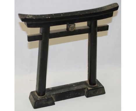 A Japanese ebonised shrine torii gate figure with brass central mount 11" high 