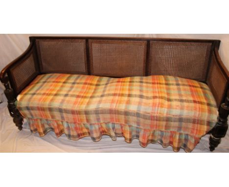 A 19th Century beech three-seat settee with cane work back and sides, upholstered seat on turned tapered legs, 73" long