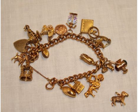 A 9ct gold charm bracelet supporting various 9ct gold and other charms (63g gross)