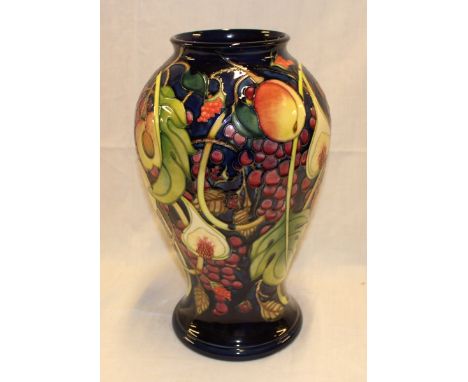 A Moorcroft pottery "Master" pattern tapered vase with fruit and leaf decoration on blue ground, impressed marks, 16" high