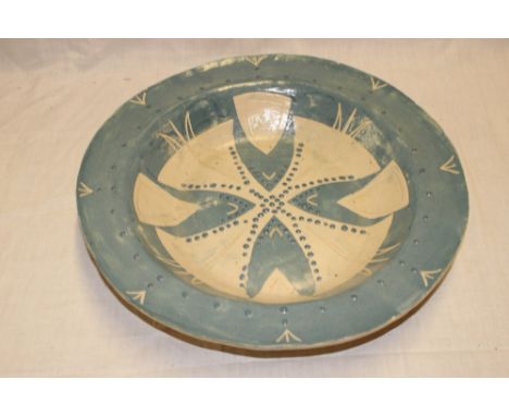 A large studio pottery circular charger with pale blue glazed decoration marked "SS", 17" diameter 
