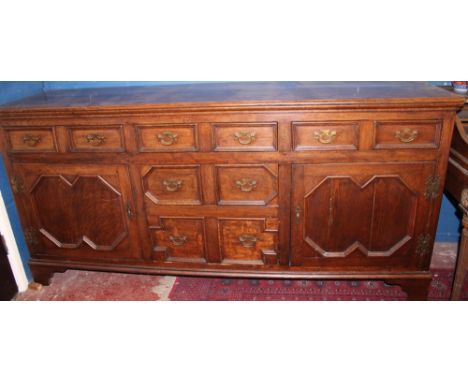 A George III-style oak dresser base with three drawers in the frieze disguised as six drawers above two central drawers flank