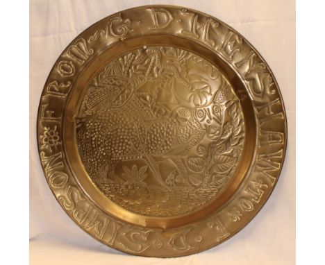A large embossed brass circular charger, the rim engraved "E. D. Simpson from D. Henshaw", 36" diameter