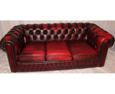 A good quality modern three-seat Chesterfield sofa upholstered in red buttoned leather, 73" long together with a matching Che