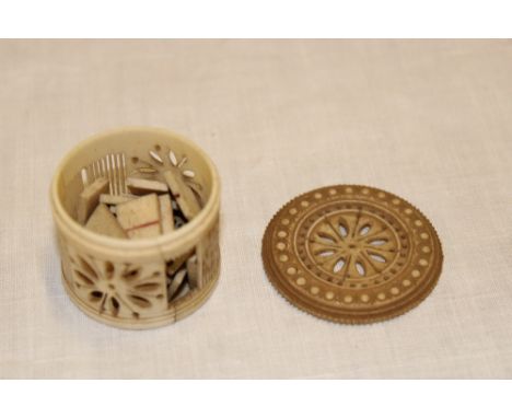 A Napoleonic prisoner of war carved bone cylindrical pocket box with pierced decoration and circular lid containing a set of 