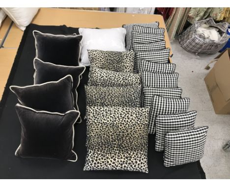 Two boxes containing five dark brown velvet cushions with cream piping, four cream and black animal print cushions, one beige