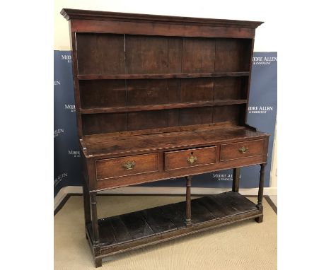 A 19th Century mahogany dresser in the 18th Century manner, the boarded two tier plate rack over three frieze drawers on turn