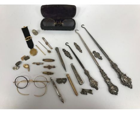 A collection of silver, gold, white metal and yellow metal items to include button hooks, propelling pencil, brooches, single