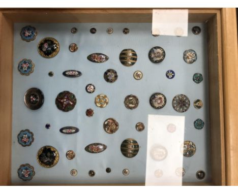 A frame containing a display of enamelled buttons, size ranging from 7-30mm diameter, 33 cm x 29 cm, the enamelling depicting