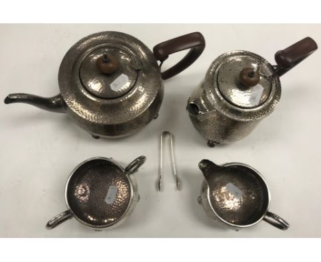 A George V beaten silver four piece tea set, raised on four paw feet (by J B Chatterley &amp; Sons, Birmingham - sugar and cr