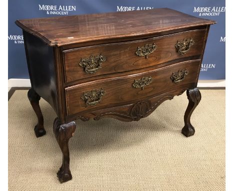 A 19th Century French elm commode, the plain serpentine fronted top with moulded edge over two long drawers, the ornate cast 