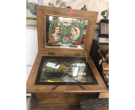 An 11 7/8 walnut and inlaid cased symphonion with internal mirrored panel to lid depicting young and old Victoria .... "50 ye