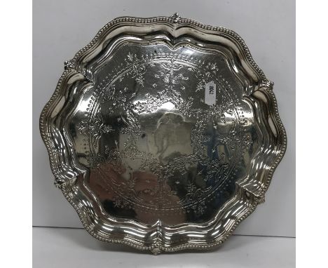 A Victorian silver salver, the beaded pie-crust rim enclosing a floral and foliate swag decorated centre field, raised on thr