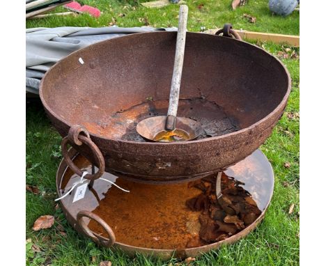 A cast iron and studded fire pit and stand with cover and wooden handled ladle, 75 cm diameter, together with a wrought iron 