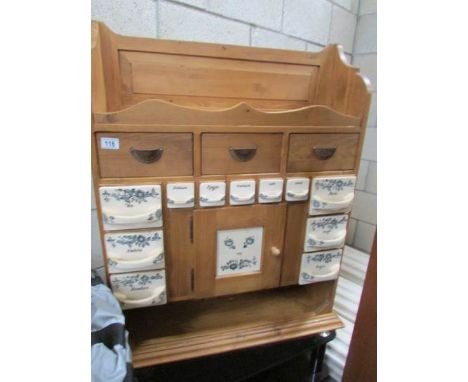 A pine spice rack with ceramic drawers