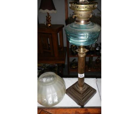 A Victorian oil lamp with Paladian column, blue glass font and etched shade (missing chimney)