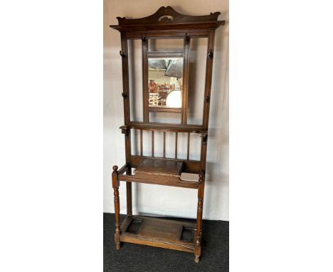 Oak hall stand, the moulded carved top above a back section with hooks and central mirror and carved shelf, the lower section