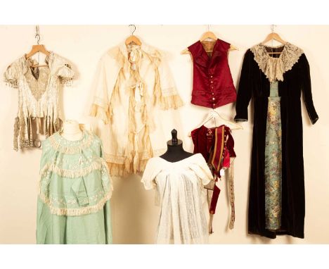 A Regency muslin dress, embroidered floral panel to front with hem and train decorated, a green embroidered cape, with cream 
