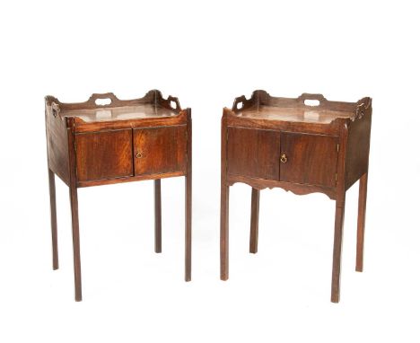A near pair of George III tray top pot cupboards, the galleried tops with pierced handles, enclosed by doors on square chamfe