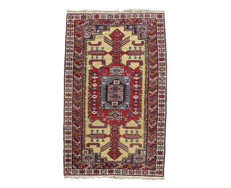 A SHIRVAN RUG SOUTH EAST CAUCASUS, POSSIBLY C.1910 the pale lemon diamond lattice field with a central panel of hooked device